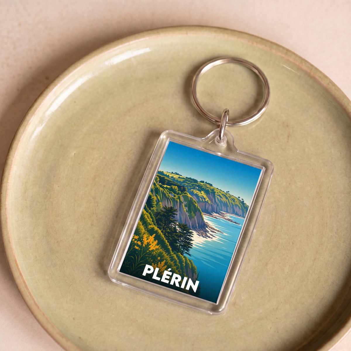 Porte-clés souvenir de la ville de Plérin avec une illustration stylisée de son paysage côtier.