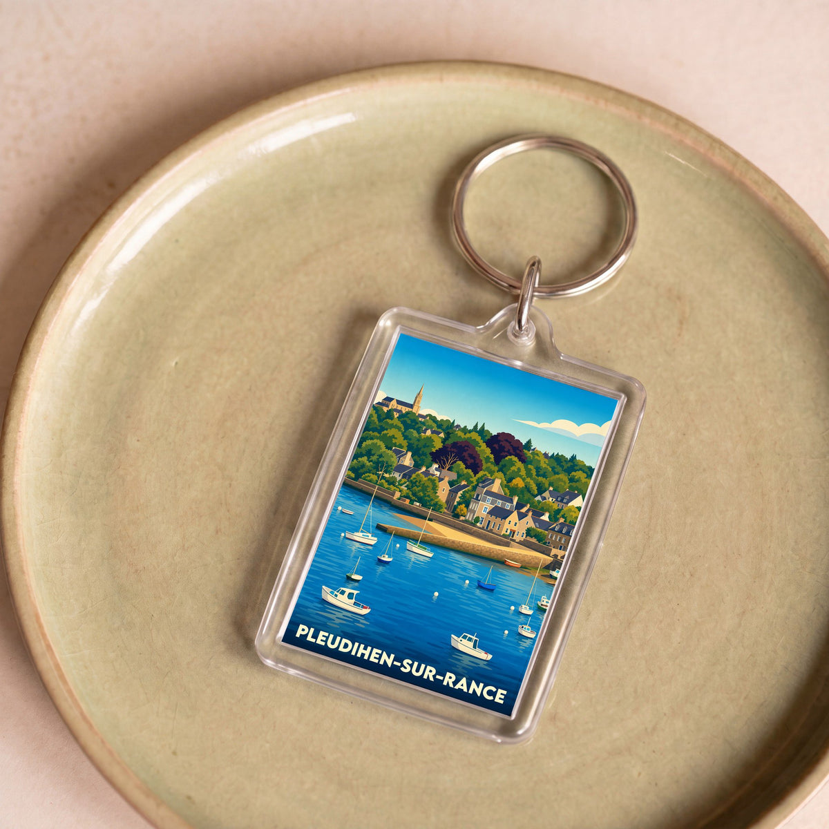 Porte-clés souvenir de la ville de Pleudihen-sur-Rance avec une illustration stylisée de son port.