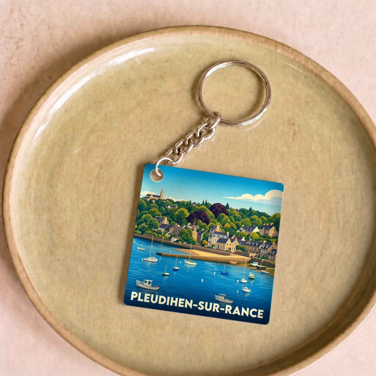 Porte-clés souvenir de la ville de Pleudihen-sur-Rance avec une illustration stylisée de son port.