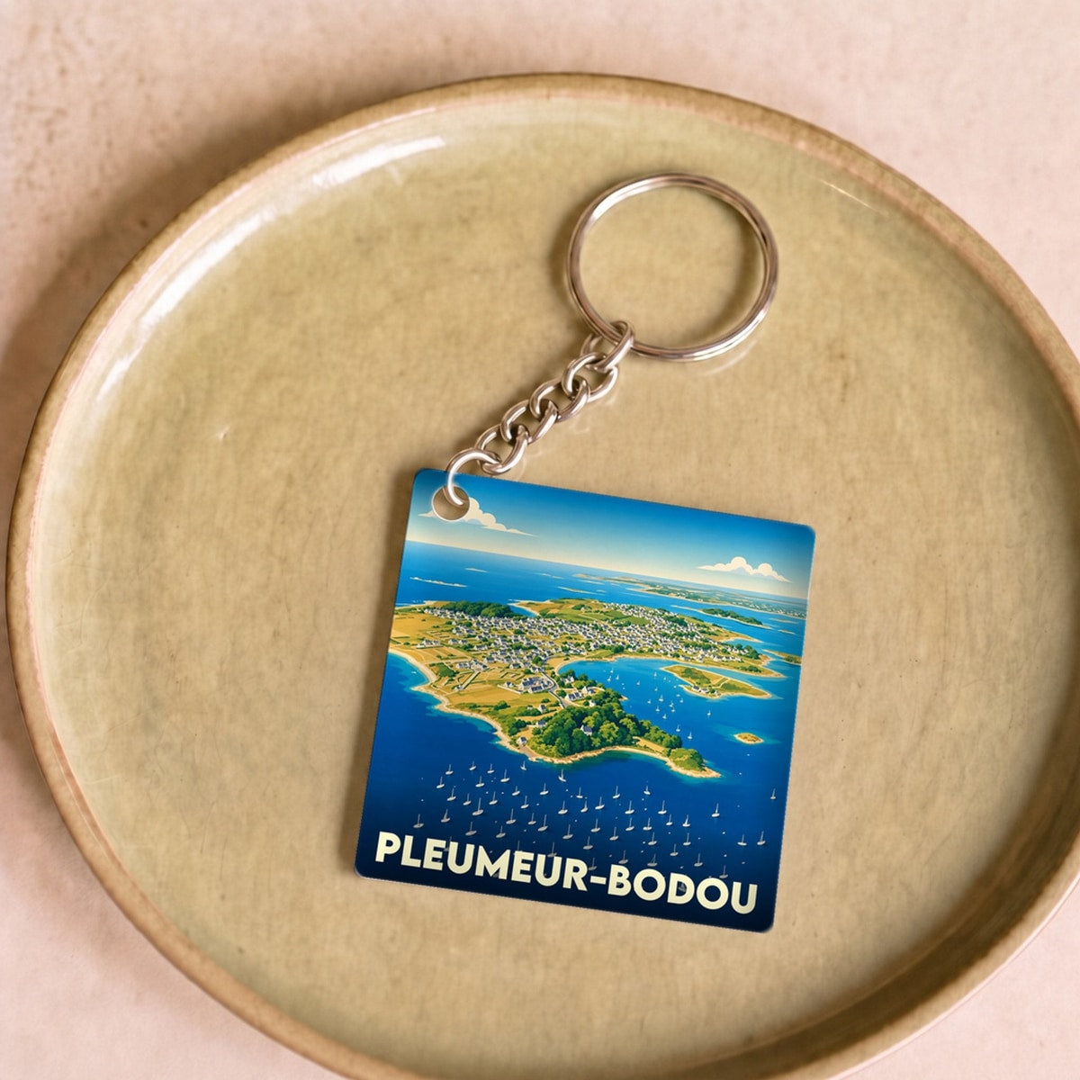 Porte-clés souvenir de la ville de Pleumeur-Bodou avec une illustration stylisée de son littoral.