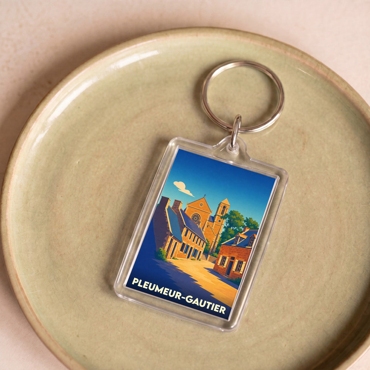 Porte-clés souvenir de la ville de Pleumeur-Gautier avec une illustration stylisée.