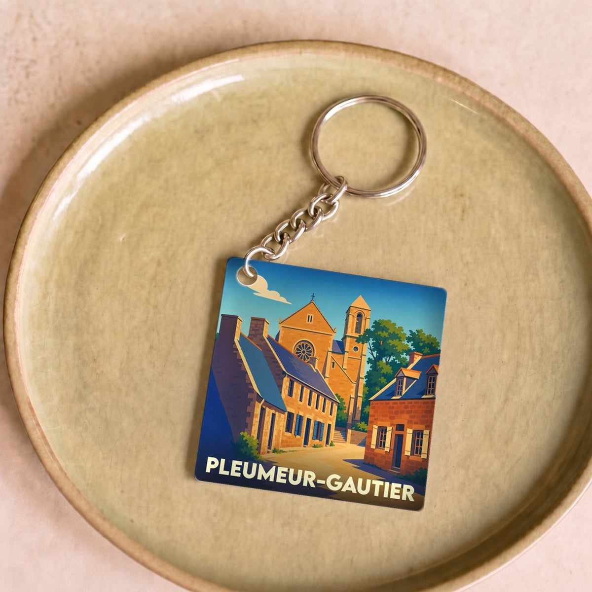 Porte-clés souvenir de la ville de Pleumeur-Gautier avec une illustration stylisée.