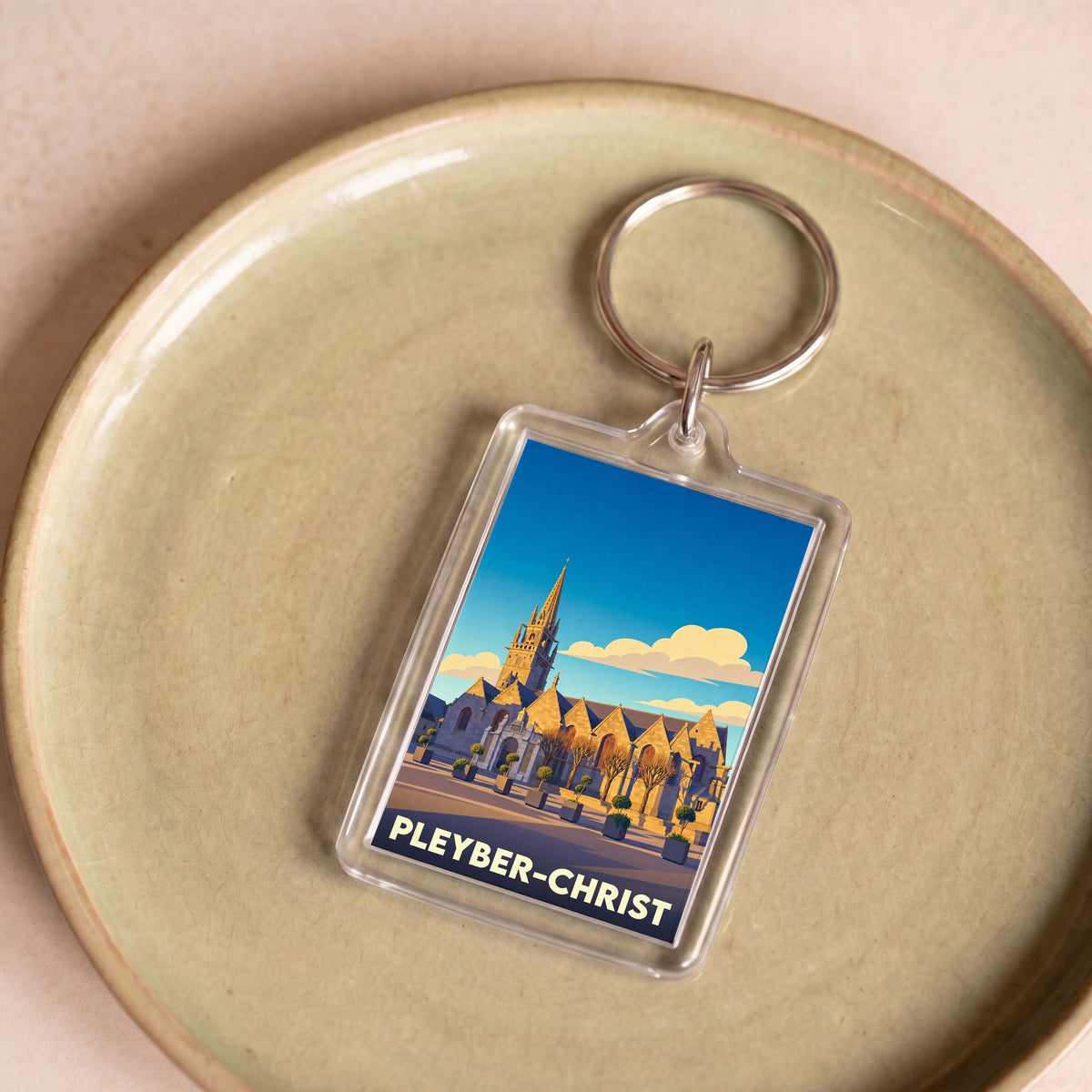 Porte-clés souvenir de la ville de Pleyber-Christ avec une illustration stylisée de son église.