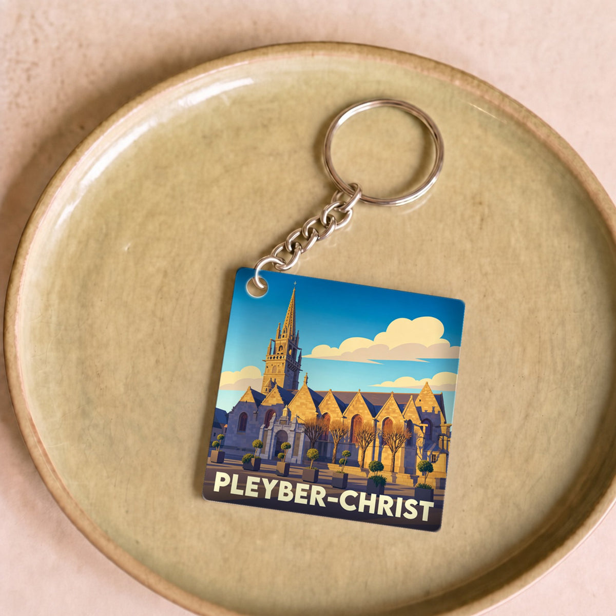 Porte-clés souvenir de la ville de Pleyber-Christ avec une illustration stylisée de son église.