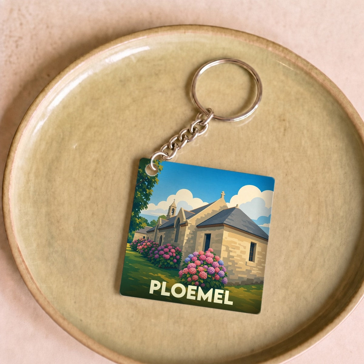 Porte-clés souvenir de la ville de Ploemel avec une illustration stylisée d'une chapelle bretonne.