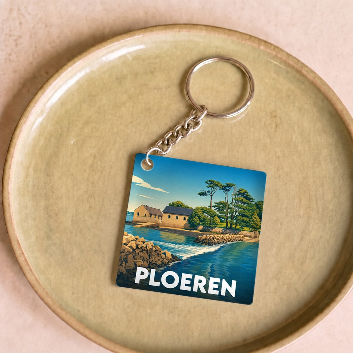 Porte-clés souvenir de la ville de Ploeren avec une illustration stylisée d'un paysage côtier.