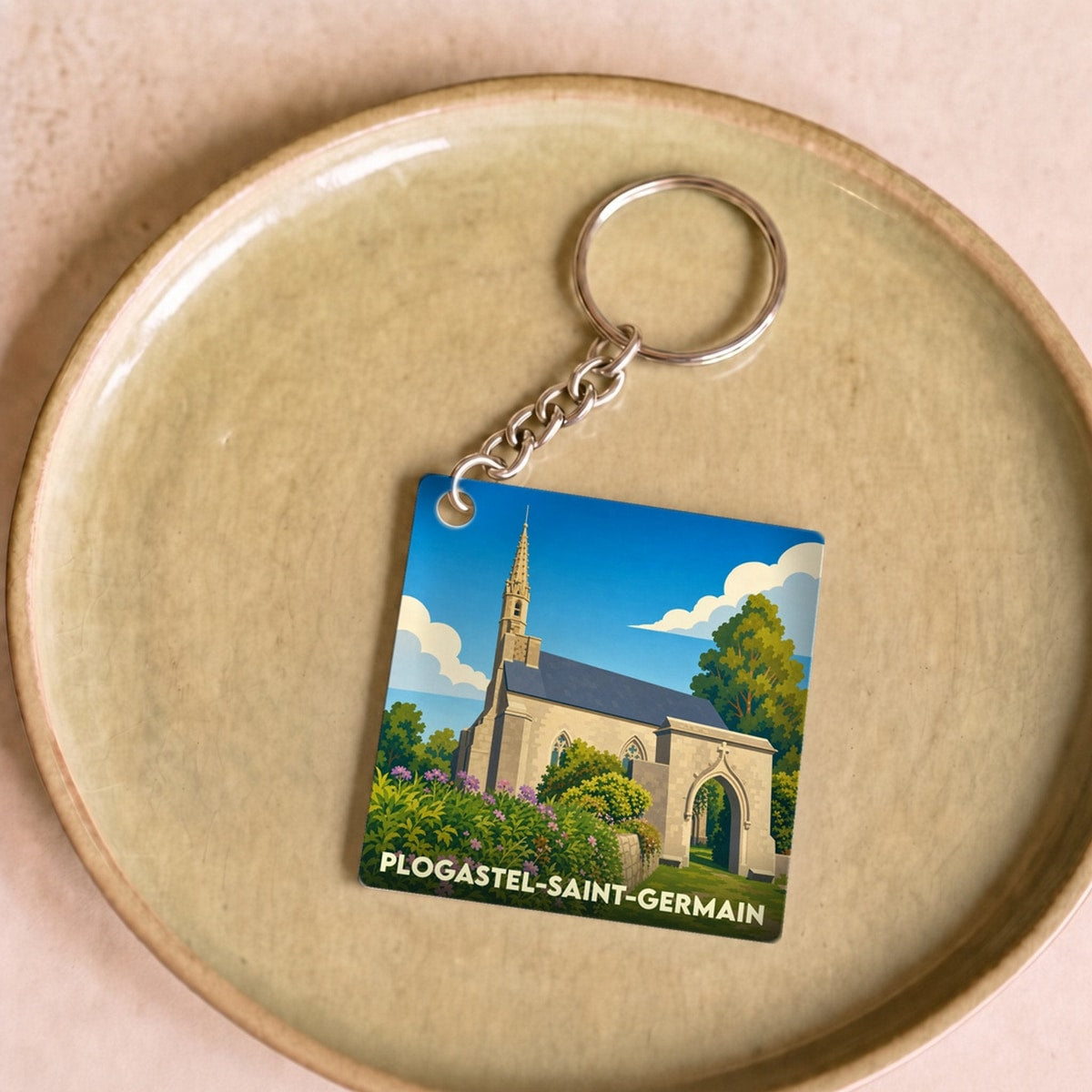 Porte-clés souvenir de la ville de Plogastel-Saint-Germain avec une illustration stylisée de son église.