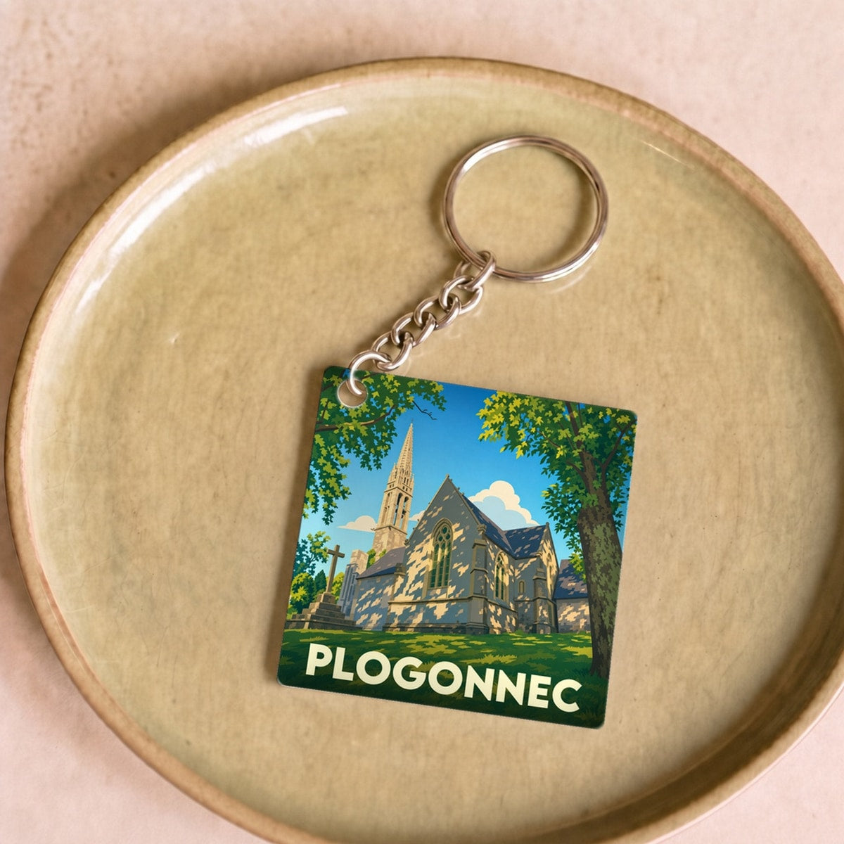 Porte-clés souvenir de la ville de Plogonnec avec une illustration stylisée de son église.