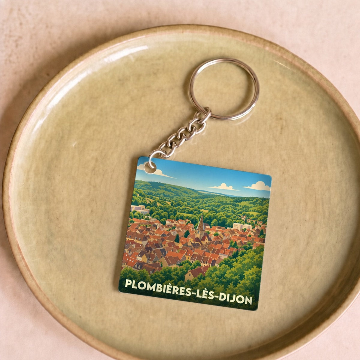 Porte-clés souvenir de la ville de Plombières-lès-Dijon avec une illustration stylisée.