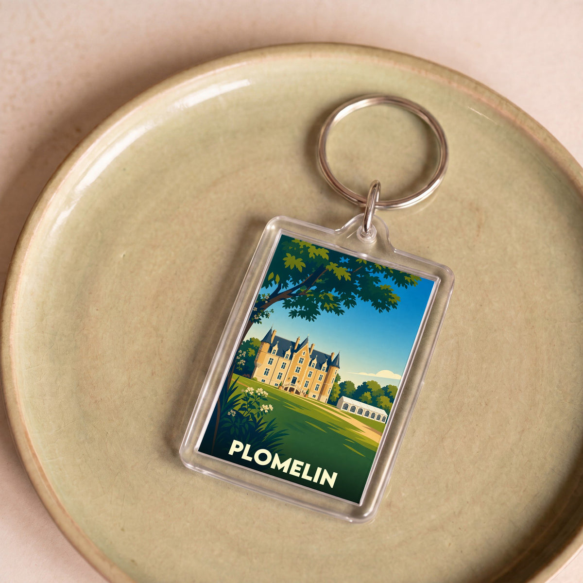 Porte-clés souvenir de la ville de Plomelin avec une illustration stylisée de château.