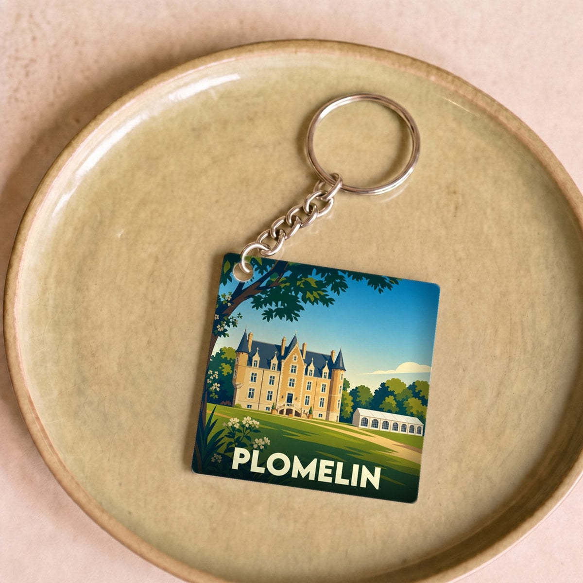Porte-clés souvenir de la ville de Plomelin avec une illustration stylisée d'un château.