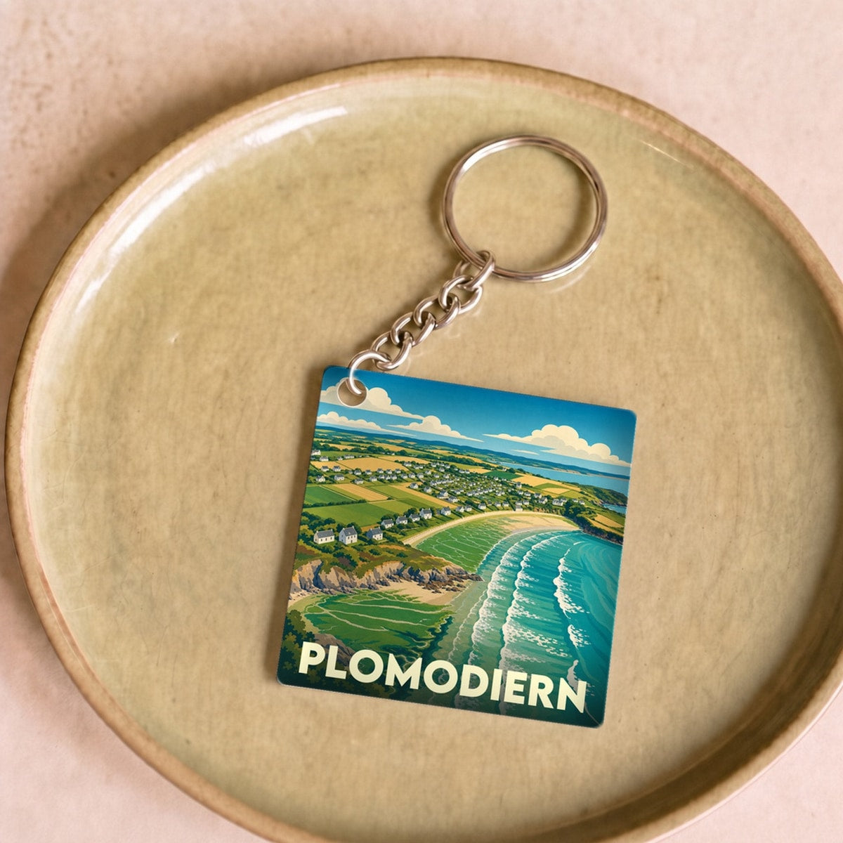 Porte-clés souvenir de la ville de Plomodiern avec une illustration stylisée de son paysage côtier.
