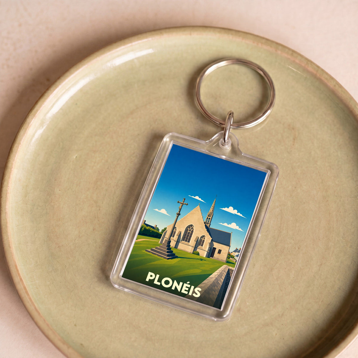 Porte-clés souvenir de la ville de Plonéis avec une illustration stylisée de son église et de son calvaire.