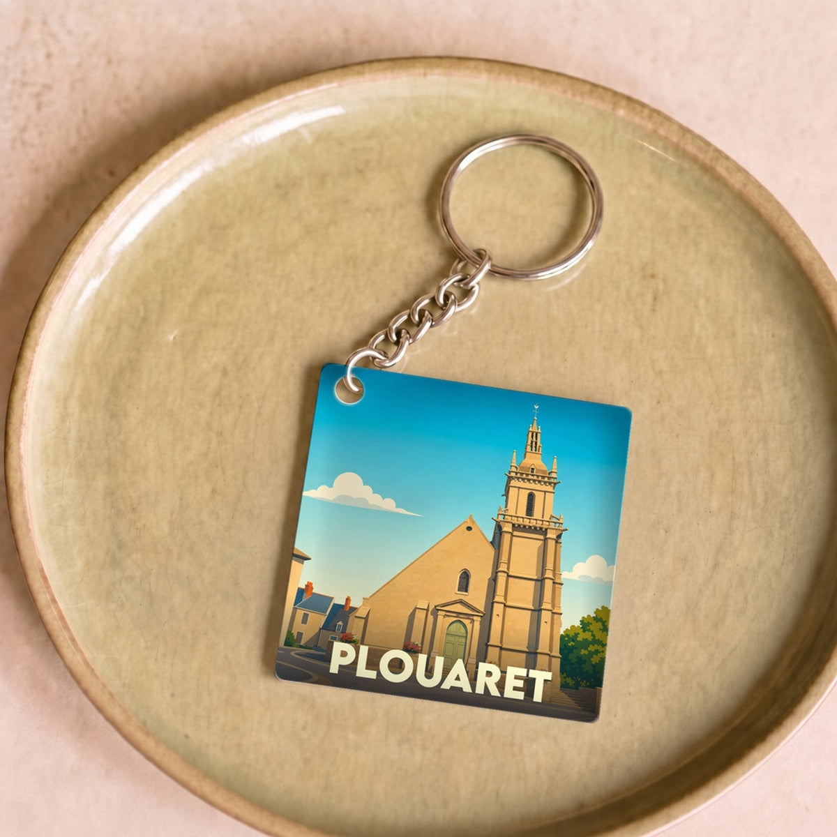 Porte-clés souvenir de la ville de Plouaret avec une illustration stylisée de son église.