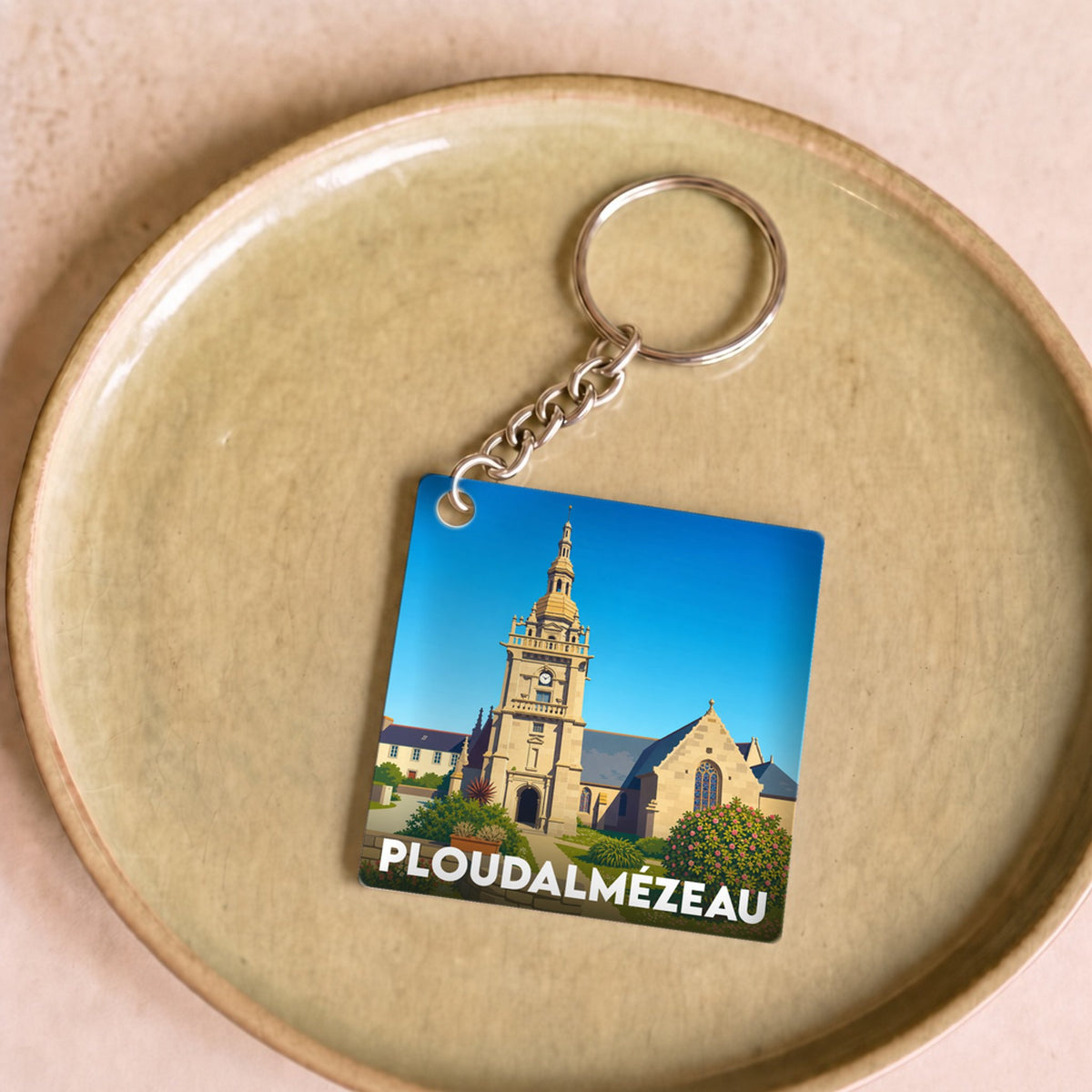 Porte-clés souvenir de la ville de Ploudalmézeau avec une illustration stylisée de son église.