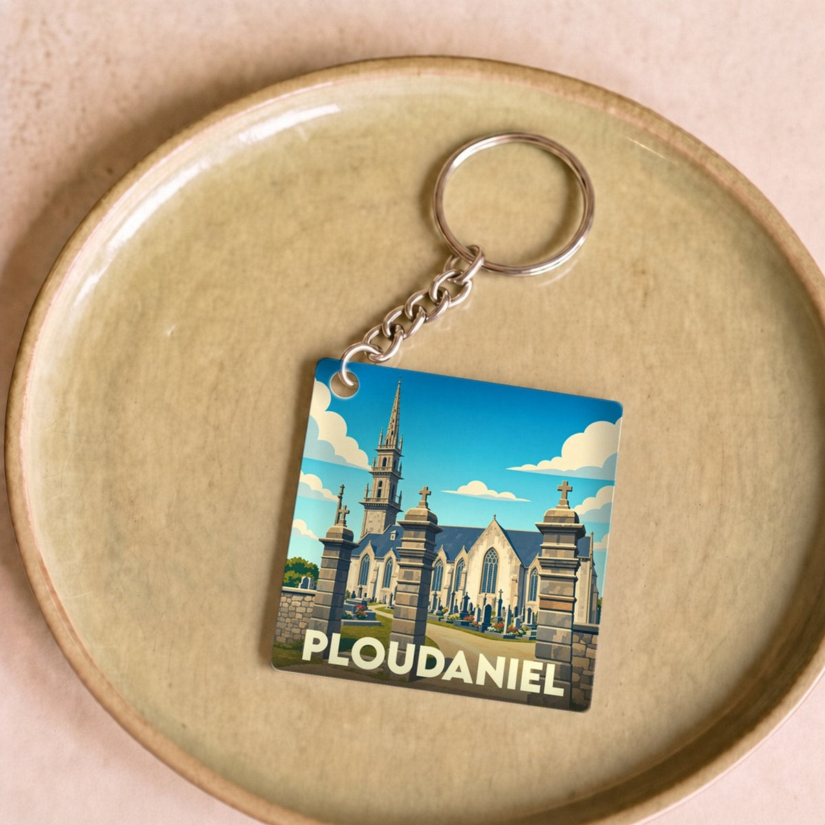 Porte-clés souvenir de la ville de Ploudaniel avec une illustration stylisée de son église.
