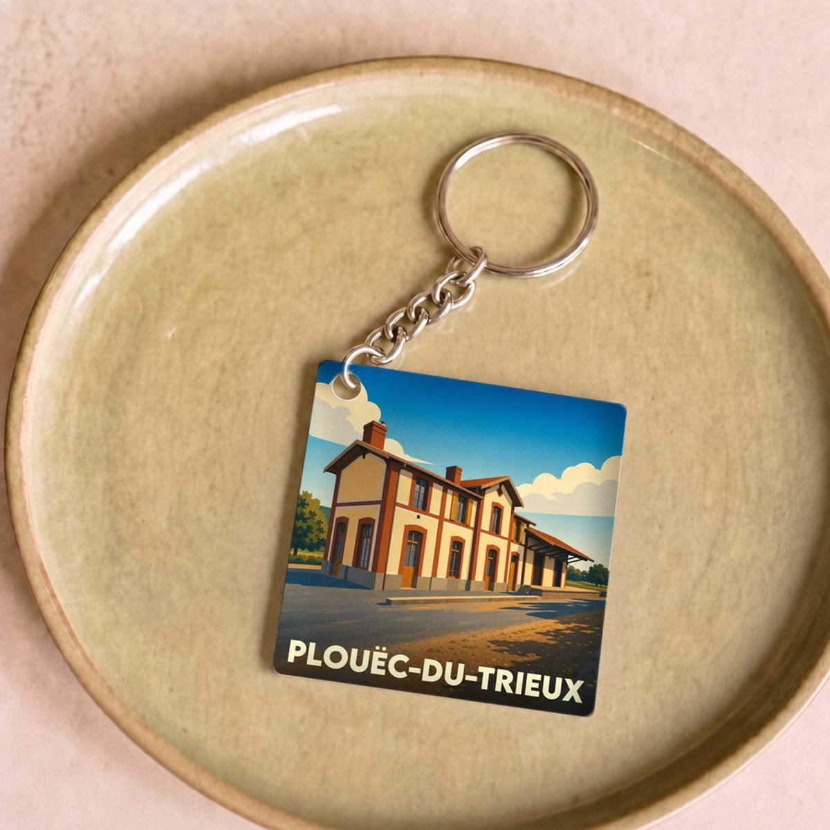 Porte-clés souvenir de la ville de Plouëc-du-Trieux avec une illustration stylisée de sa gare.