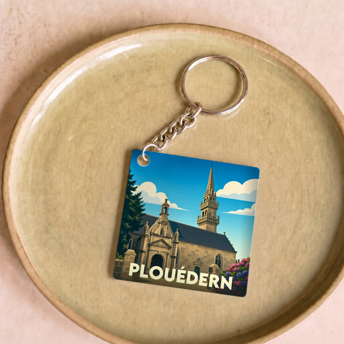 Porte-clés souvenir de la ville de Plouédern avec une illustration stylisée de son église.