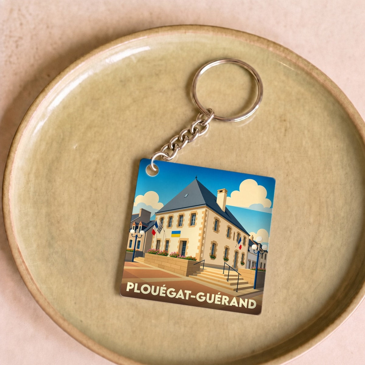 Porte-clés souvenir de la ville de Plouégat-Guérand avec une illustration stylisée de sa mairie.