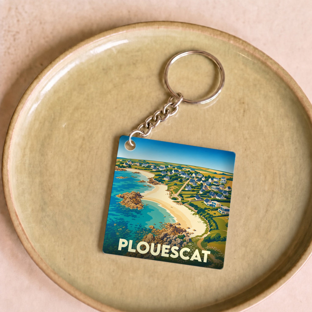 Porte-clés souvenir de la ville de Plouescat avec une illustration stylisée de sa côte littorale.