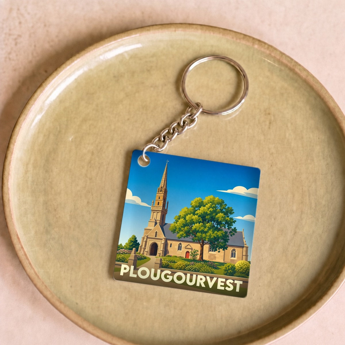 Porte-clés souvenir de la ville de Plougourvest avec une illustration stylisée de son église.