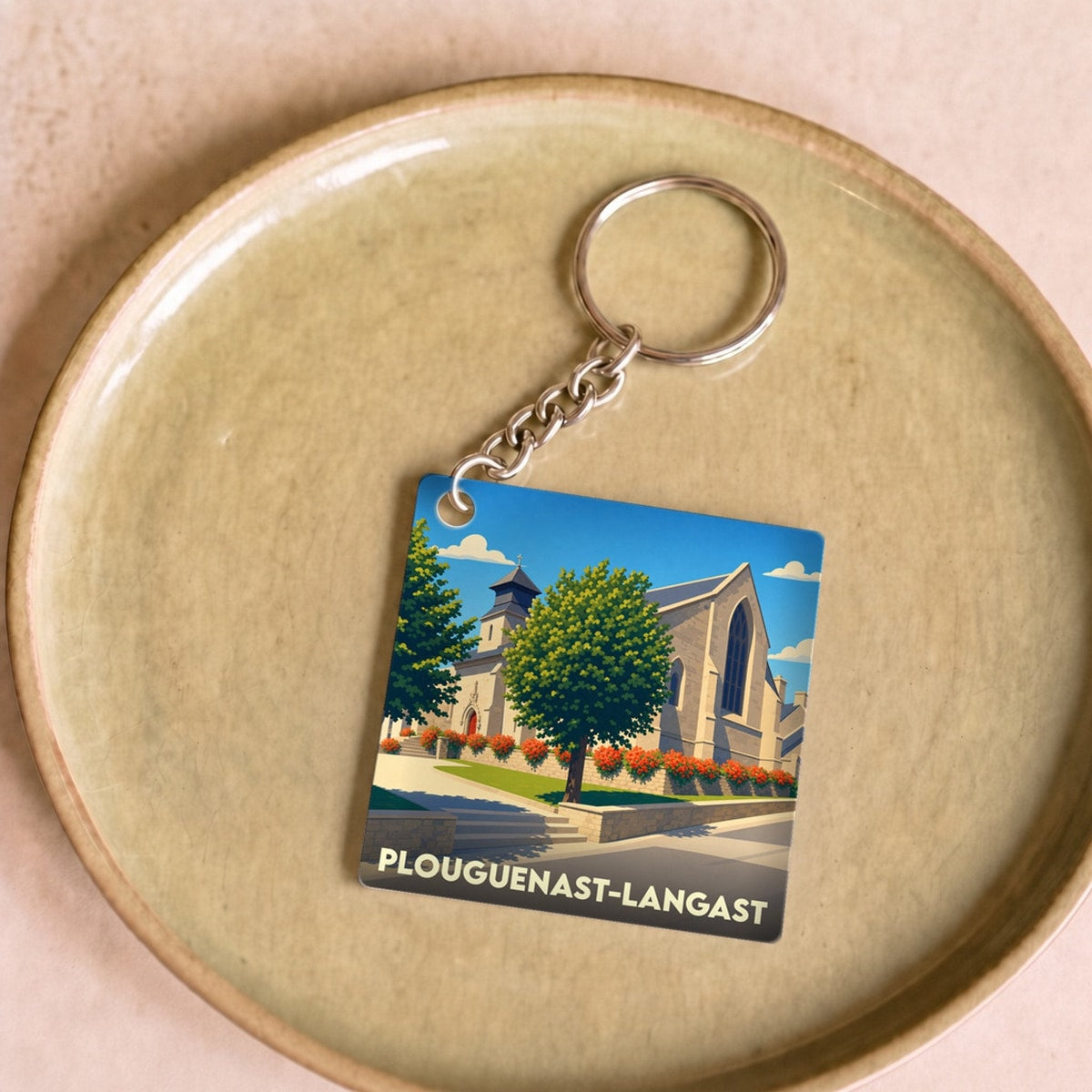 Porte-clés souvenir de la ville de Plouguenast-Langast avec une illustration stylisée de son église.