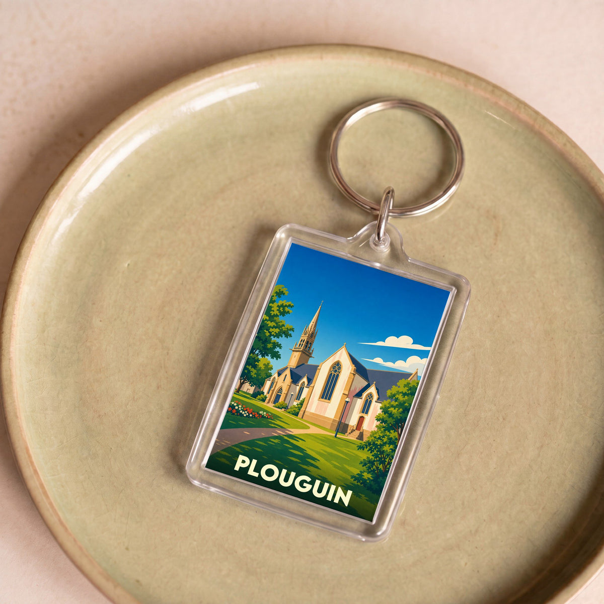 Porte-clés souvenir de la ville de Plouguin avec une illustration stylisée de son église.