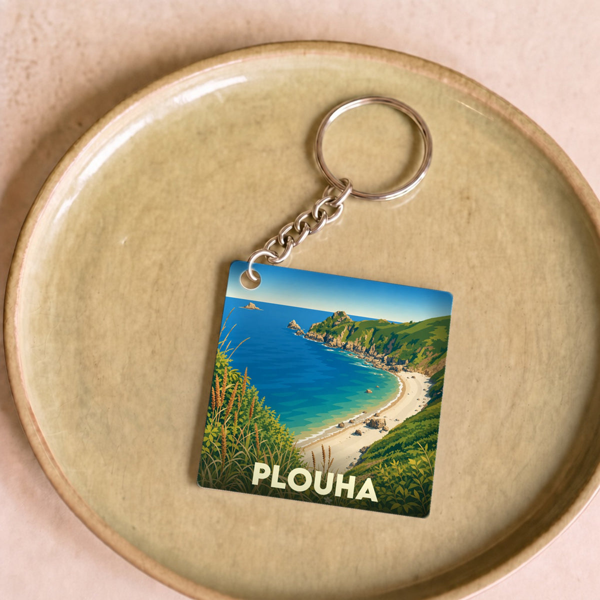 Porte-clés souvenir de la ville de Plouha avec une illustration stylisée de ses falaises et de la plage.