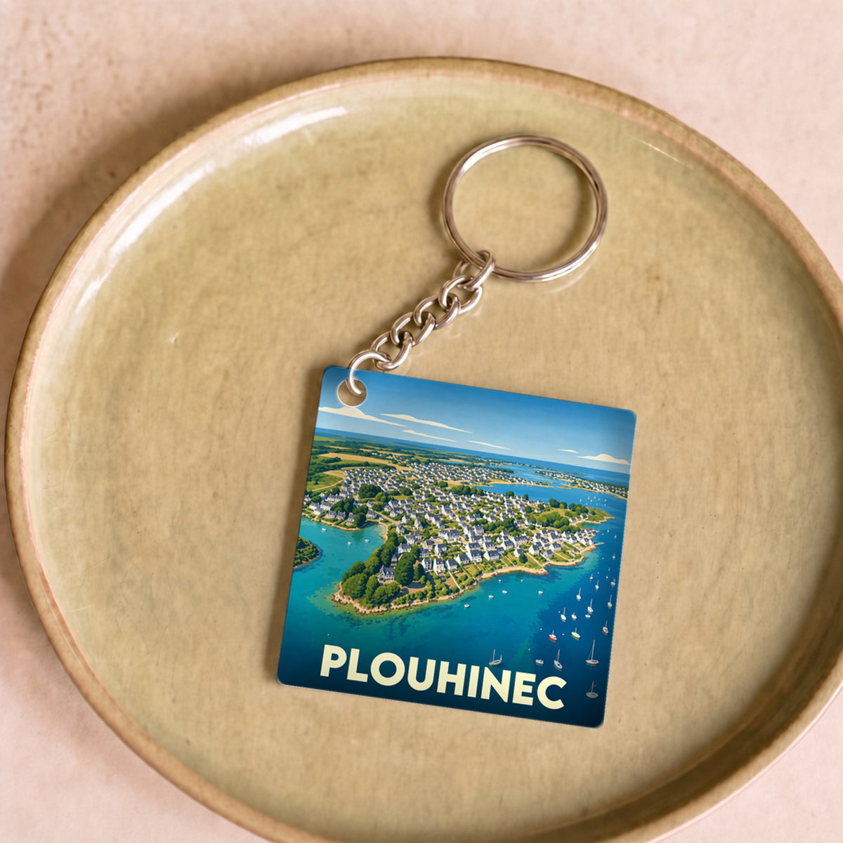 Porte-clés souvenir de la ville de Plouhinec avec une illustration aérienne stylisée de la côte.
