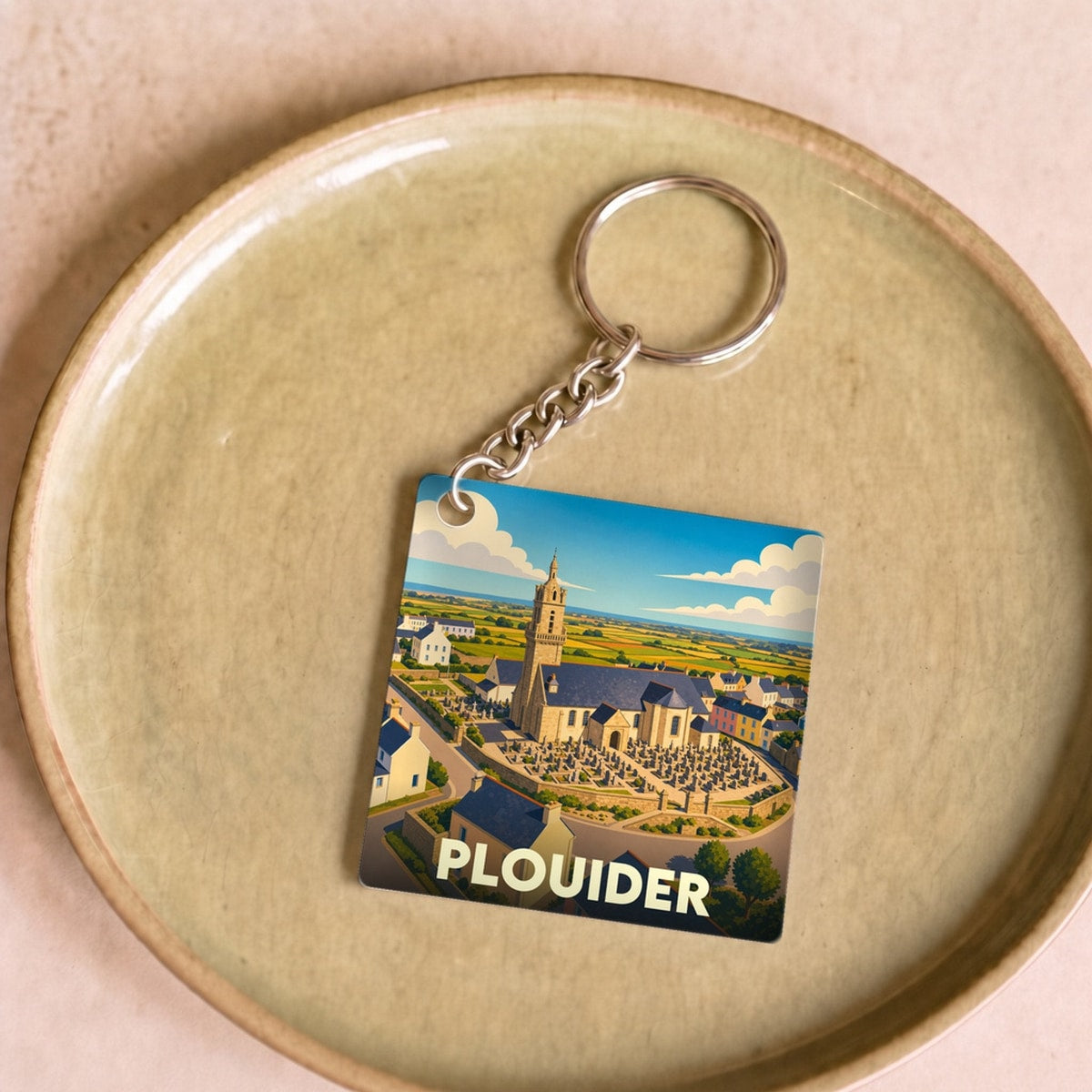 Porte-clés souvenir de la ville de Plouider avec une illustration stylisée de son église.