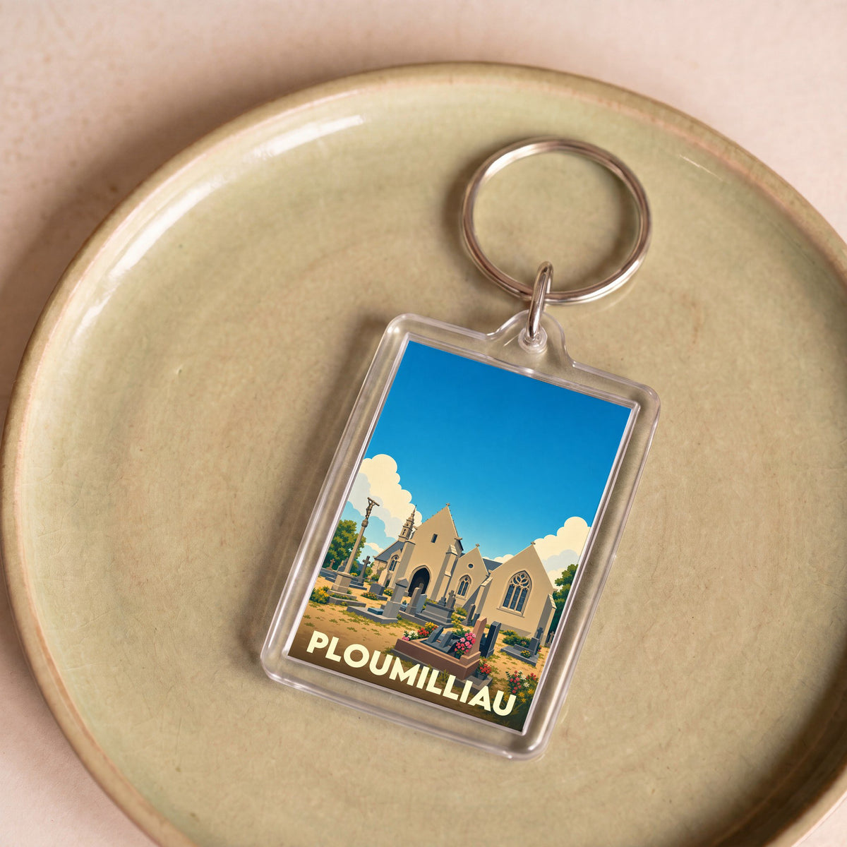 Porte-clés souvenir de la ville de Ploumilliau avec une illustration stylisée de son église et de son cimetière.