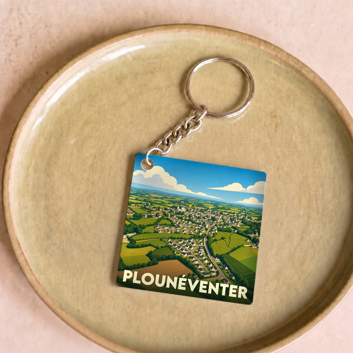 Porte-clés souvenir de la ville de Plounéventer avec une illustration stylisée vue du ciel.