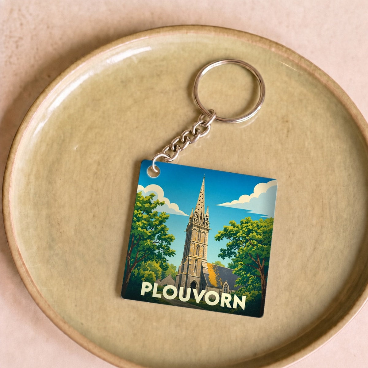 Porte-clés souvenir de la ville de Plouvorn avec une illustration stylisée de son église.