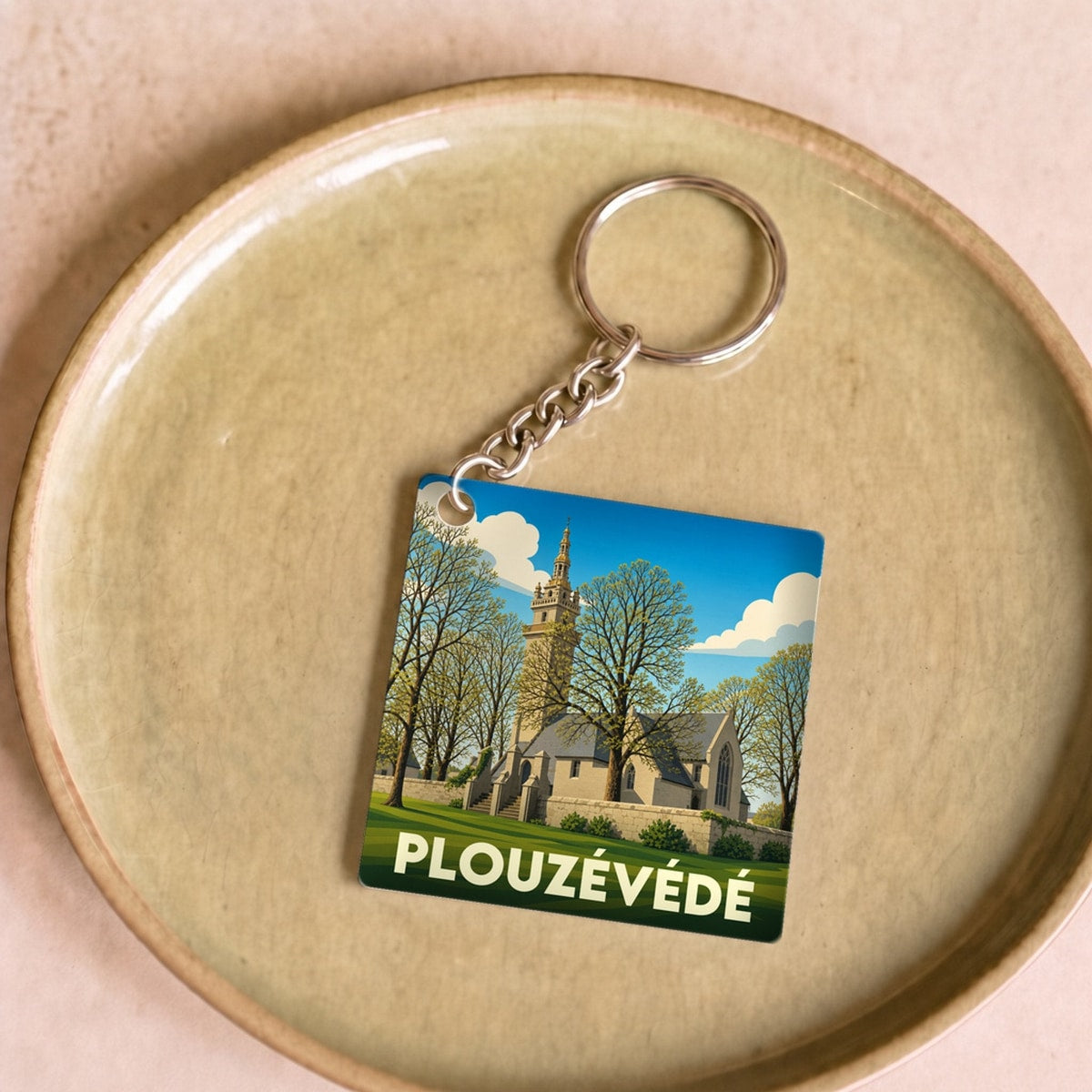 Porte-clés souvenir de la ville de Plouzévédé avec une illustration stylisée de son église.