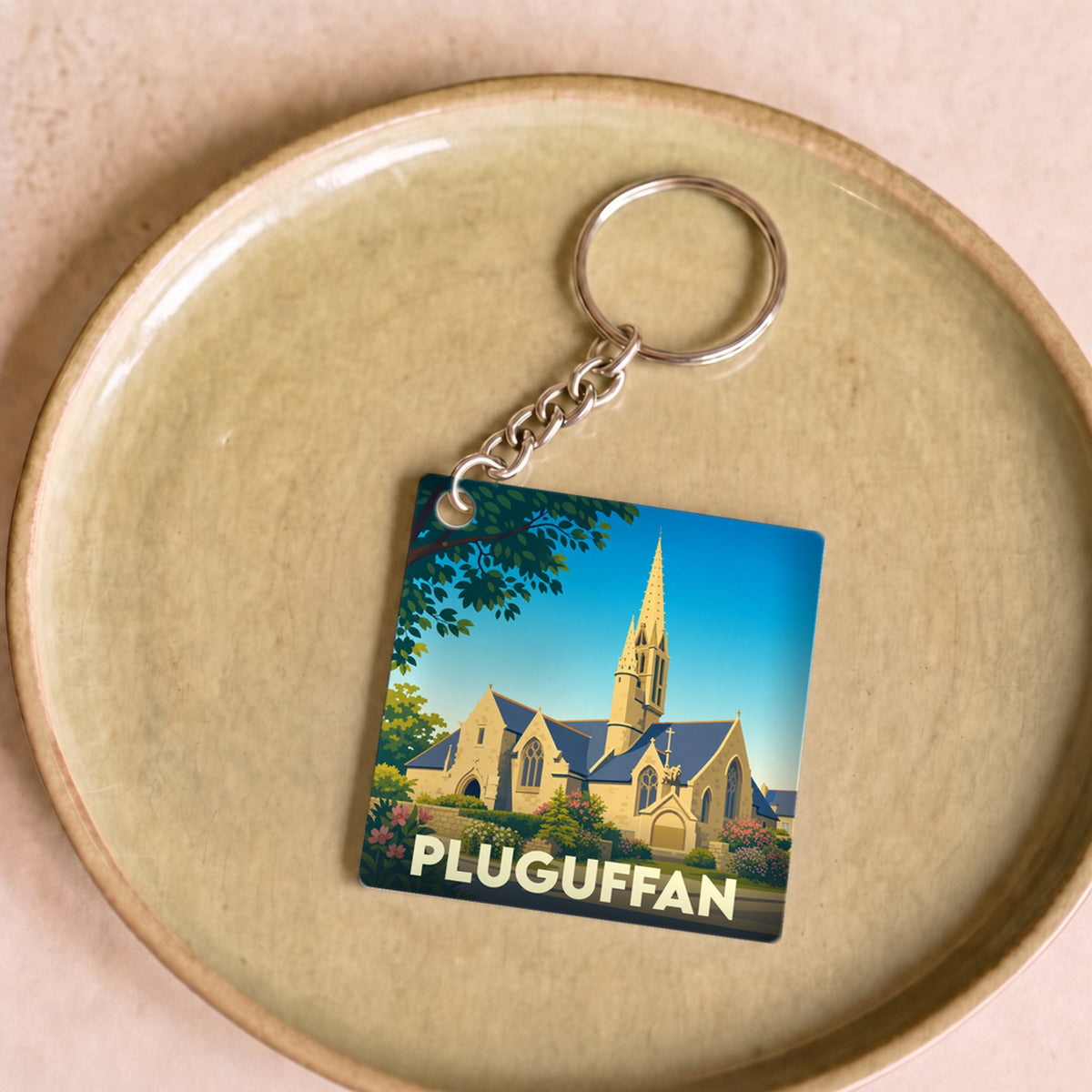 Porte-clés souvenir de la ville de Pluguffan avec une illustration stylisée de son église.
