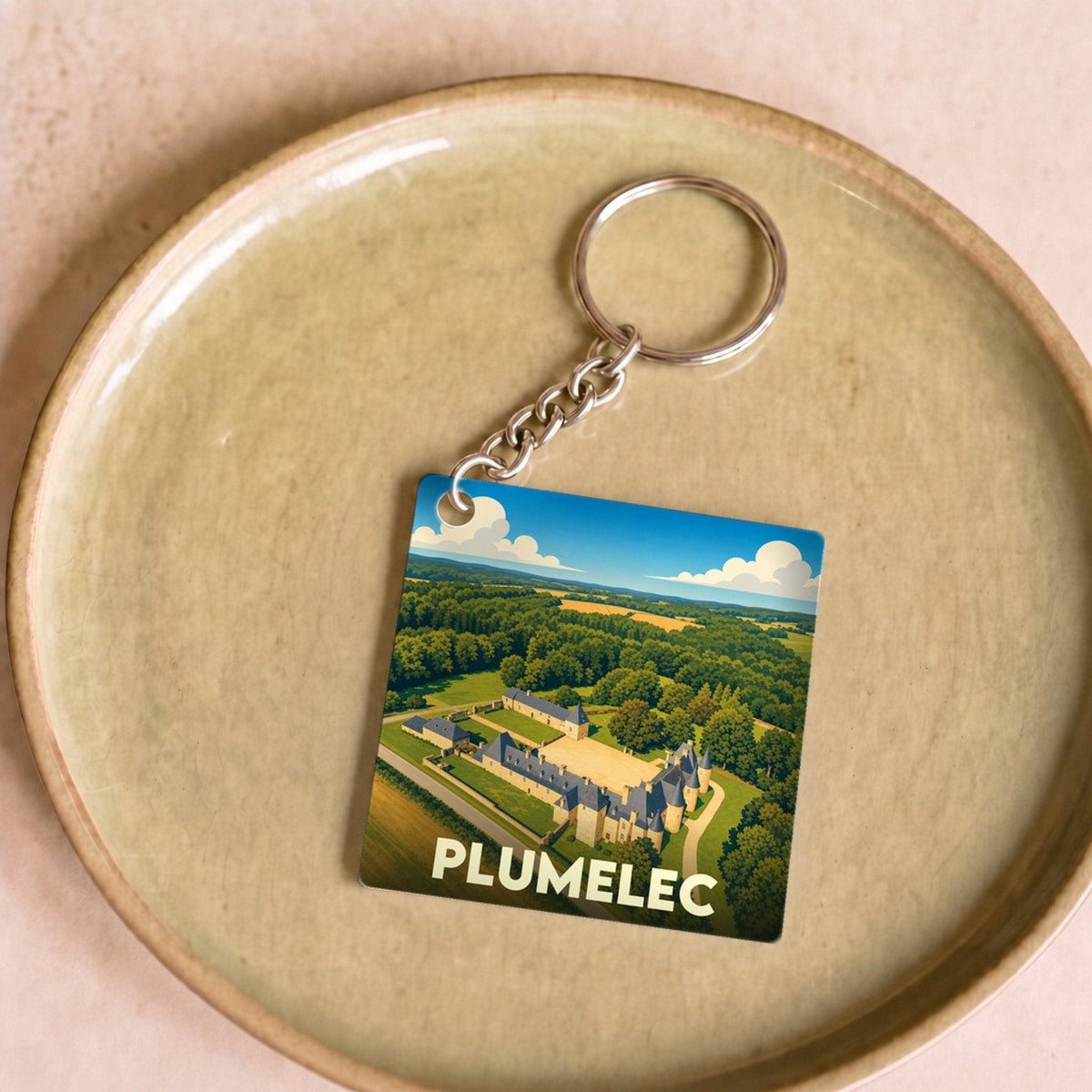 Porte-clés souvenir de la ville de Plumelec avec une illustration aérienne stylisée du château de Callac.