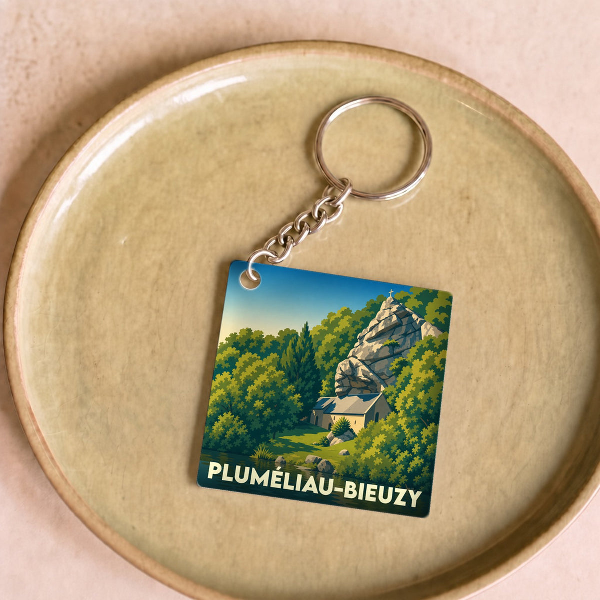 Porte-clés souvenir de la ville de Pluméliau-Bieuzy avec une illustration stylisée.