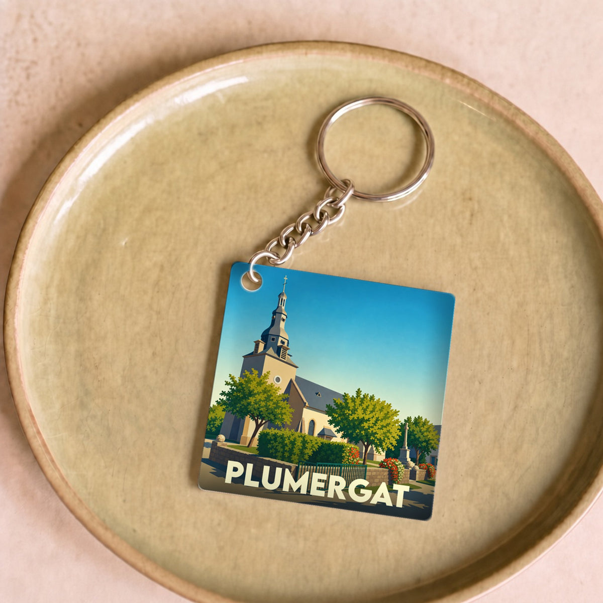 Porte-clés souvenir de la ville de Plumergat avec une illustration stylisée de son église.