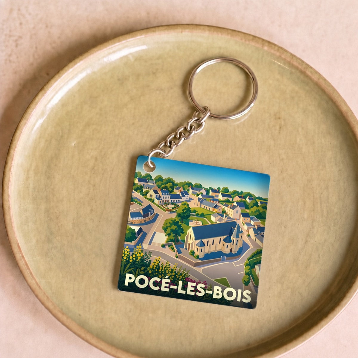 Porte-clés souvenir de la ville de Pocé-les-Bois avec une illustration stylisée.