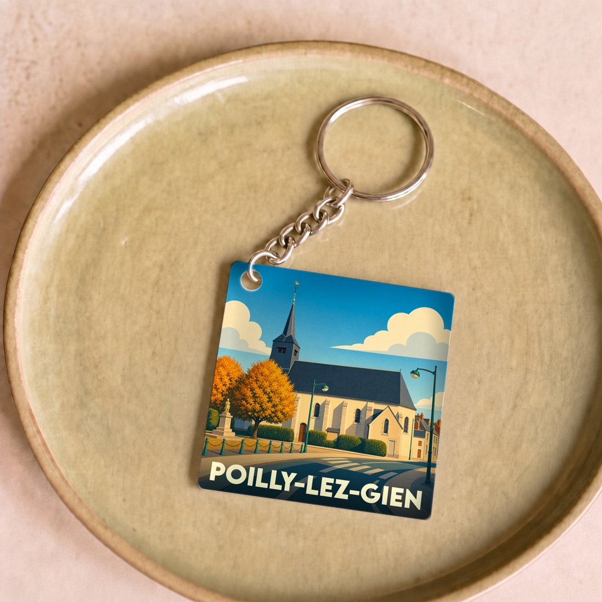 Porte-clés souvenir de la ville de Poilly-lez-Gien avec une illustration stylisée de son église.