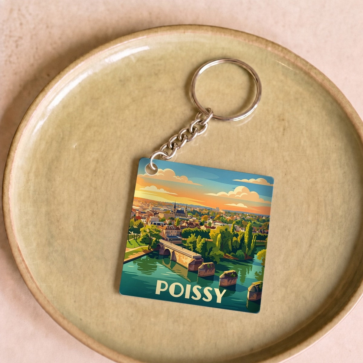 Porte-clés souvenir de la ville de Poissy avec une illustration stylisée de son paysage.