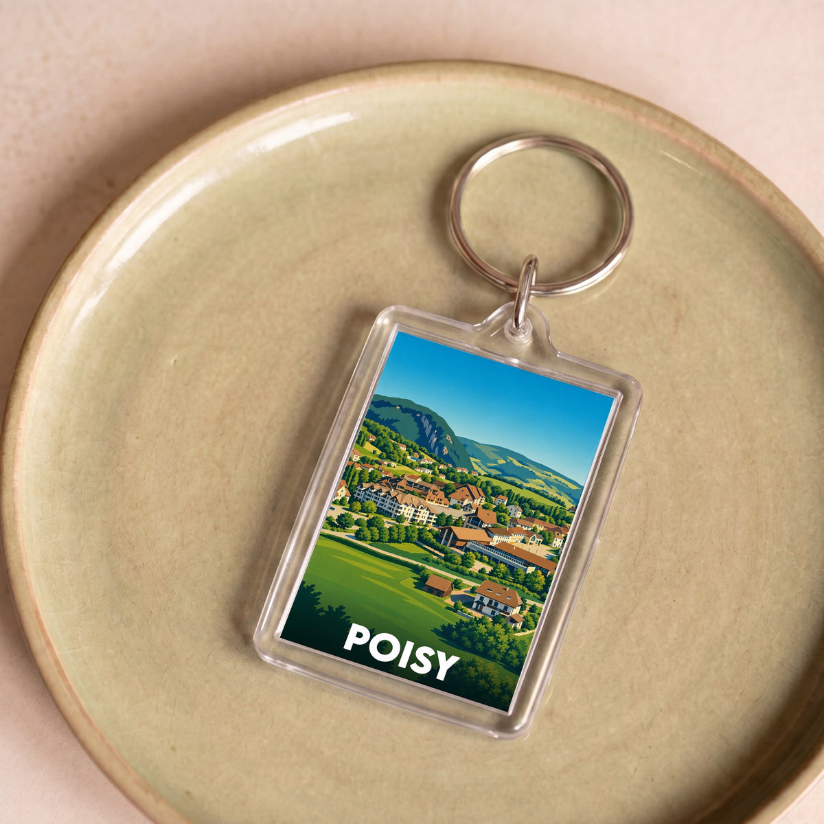 Porte-clés souvenir de la ville de Poisy avec une illustration de paysage coloré.