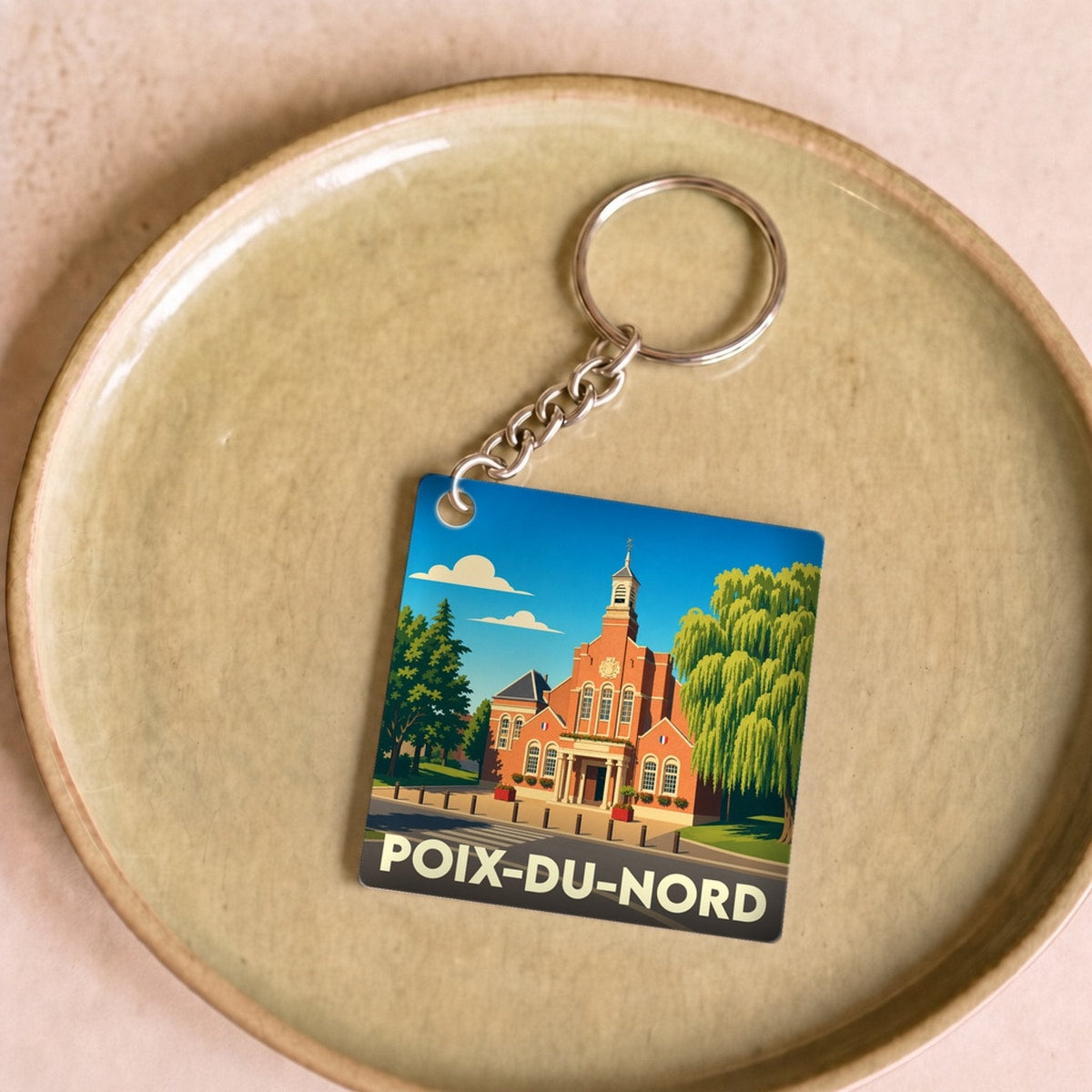 Porte-clés souvenir de la ville de Poix-du-Nord avec une illustration stylisée de son hôtel de ville.