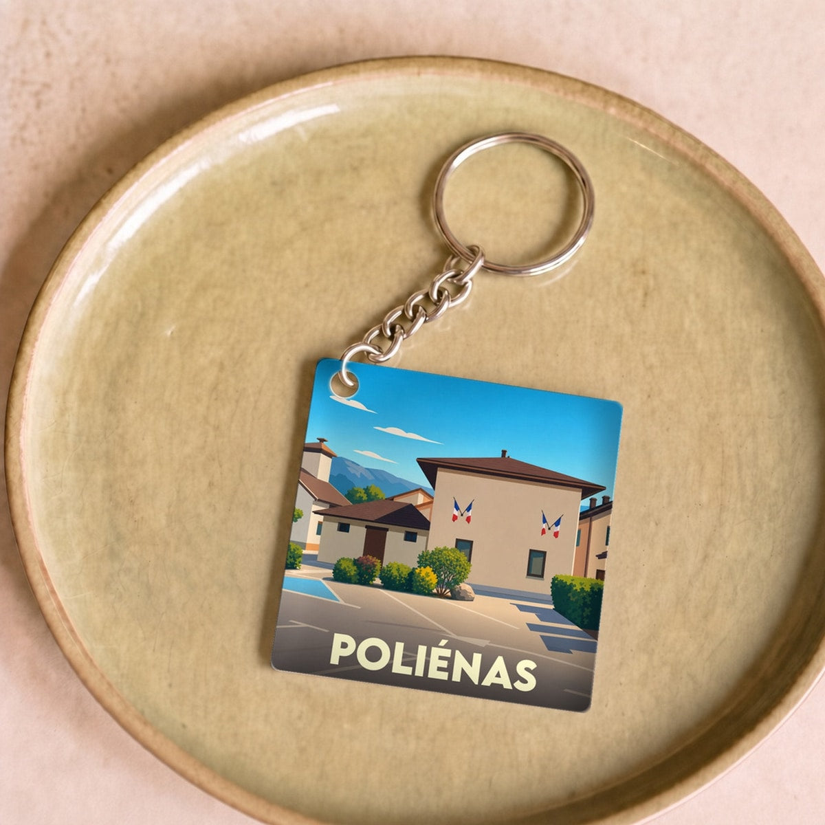 Porte-clés souvenir de la ville de Poliénas avec une illustration stylisée de sa mairie.