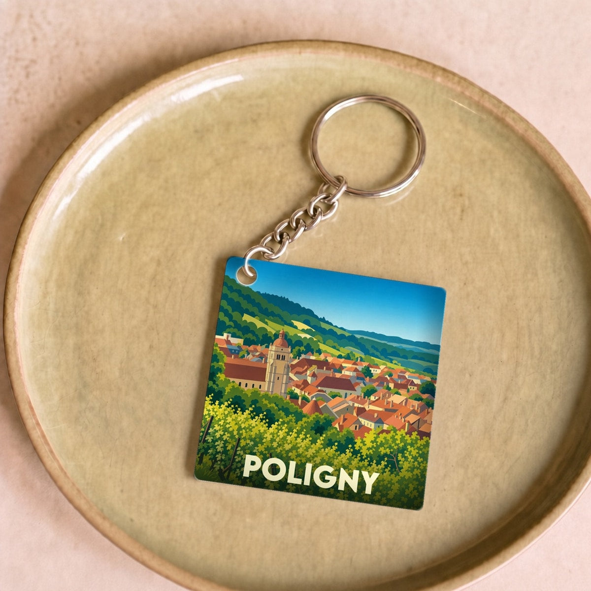 Porte-clés souvenir de la ville de Poligny avec une illustration stylisée de ses paysages et de son église.