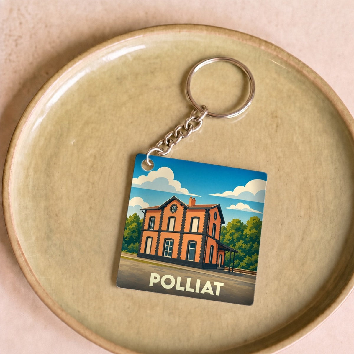Porte-clés souvenir de la ville de Polliat avec une illustration stylisée de son ancienne gare.
