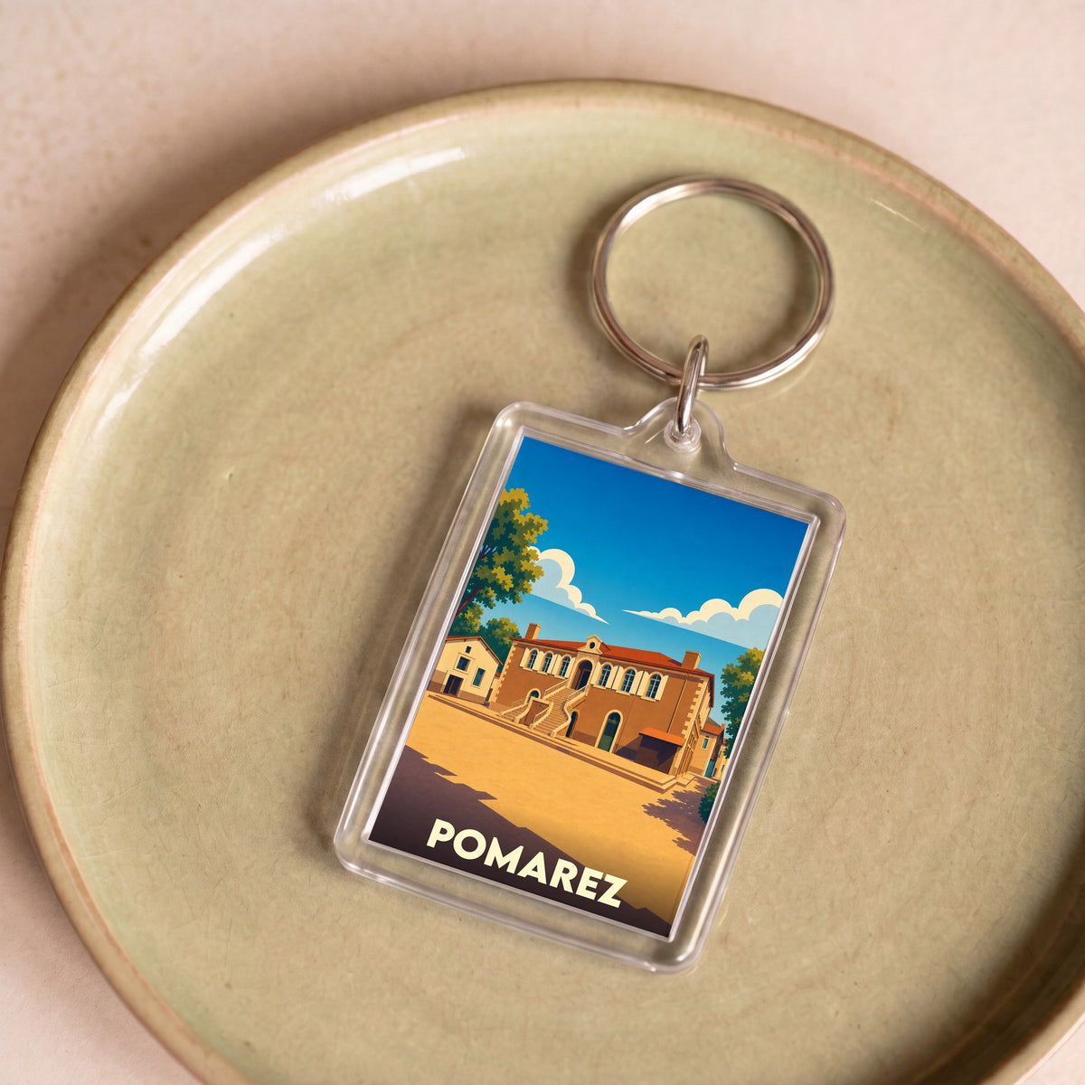 Porte-clés souvenir de la ville de Pomarez avec une illustration stylisée.