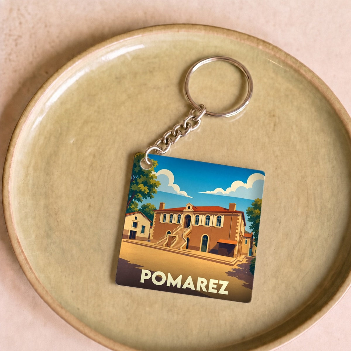 Porte-clés souvenir de la ville de Pomarez avec une illustration stylisée.