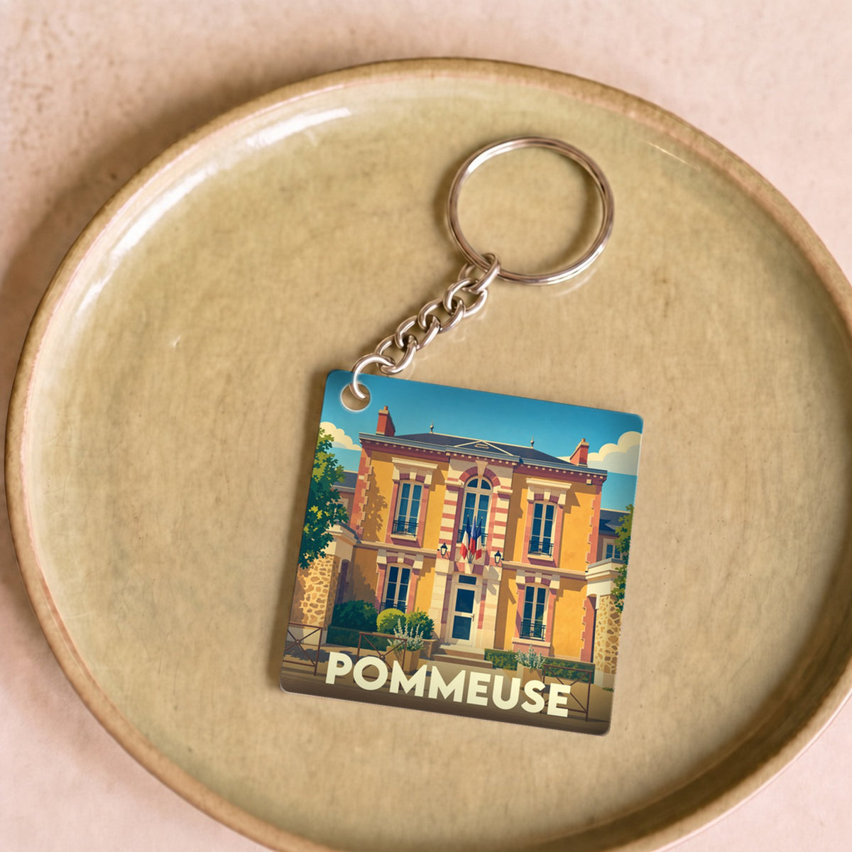 Porte-clés souvenir de la ville de Pommeuse avec une illustration stylisée de sa mairie.