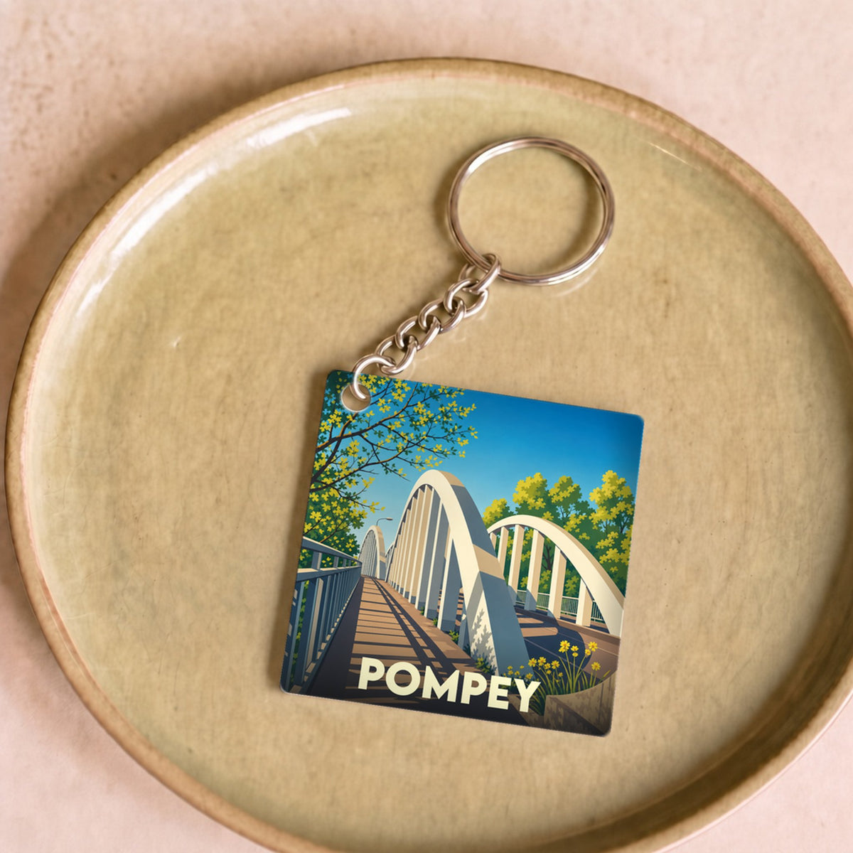 Porte-clés souvenir de la ville de Pompey avec une illustration stylisée de son pont.